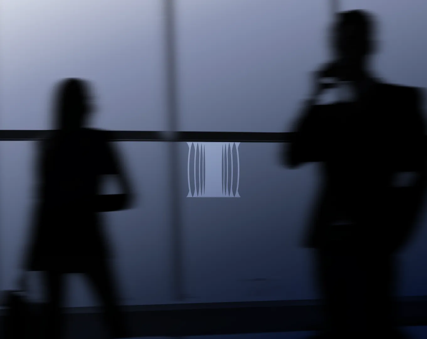 Two blurred silhouettes passing a frosted glass wall carrying the Relayzero pillar mark.